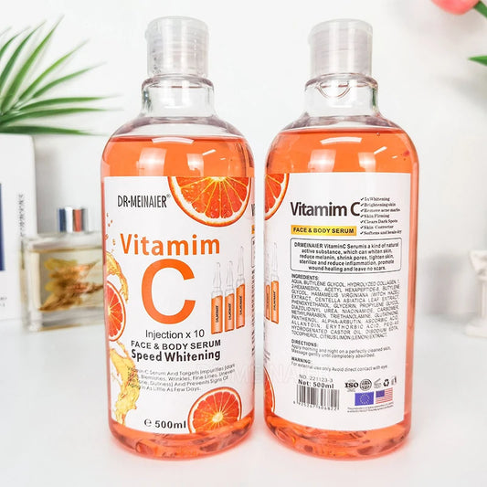 Two bottles of Dr. Meinauer Vitamin C serum on a white surface with a blurred background.