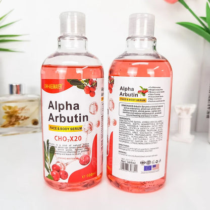 Two Alpha Arbutin face and body serum bottles on a white surface with a blurred background.